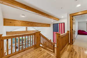 Hall featuring hardwood / wood-style floors and beam ceiling