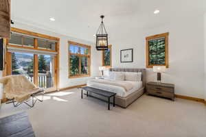 Bedroom featuring access to exterior, an inviting chandelier, and light colored carpet