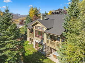 Back of property featuring a yard and a mountain view