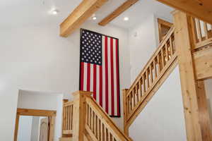 Staircase featuring beam ceiling