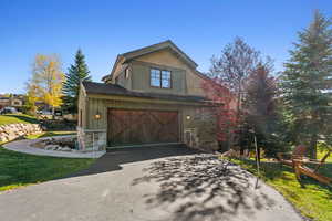 View of property exterior with a yard and a garage