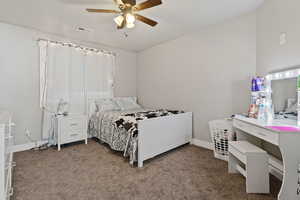 Carpeted bedroom featuring ceiling fan