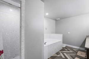 Bathroom featuring vanity, parquet floors, and separate shower and tub