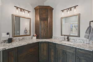 Bathroom with vanity and vaulted ceiling