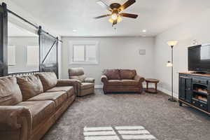 Carpeted living room featuring a textured ceiling and ceiling fan