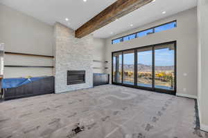 living room featuring a mountain view, a high ceiling, beamed ceiling, and a fireplace