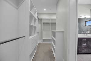 Spacious closet with sink and light tile patterned floors