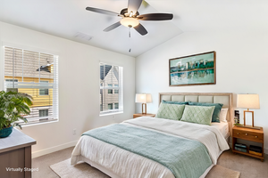 Digitally Staged - Bedroom with vaulted ceiling, light colored carpet, and ceiling fan