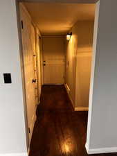 Hallway with dark hardwood / wood-style flooring