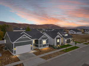 View of front of property featuring a mountain view, a garage, and central AC unit