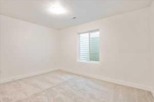 Carpeted spare room featuring a textured ceiling