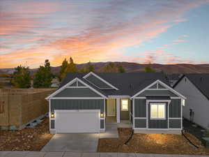 View of front of home with a mountain view and a garage