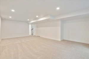 Basement featuring light colored carpet