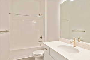 Full bathroom featuring toilet, vanity, and tub / shower combination