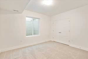 Unfurnished bedroom with a closet and light carpet