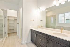 Bathroom with vanity, a shower with shower door, and tile patterned flooring