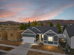 View of front of home with a mountain view and a garage