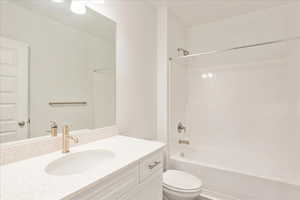 Full bathroom with vanity, toilet, and  shower combination