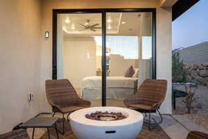 Patio terrace at dusk with an outdoor fire pit and ceiling fan