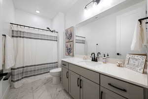 Bathroom with vanity, curtained shower, and toilet