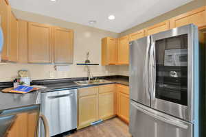 Kitchen featuring sink, appliances with stainless steel finishes, light hardwood / wood-style flooring, and light brown cabinets