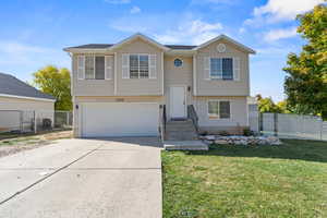 Raised ranch with a garage and a front yard