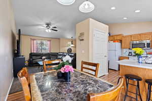 Dining room with lofted ceiling, light wood-type flooring, and ceiling fan