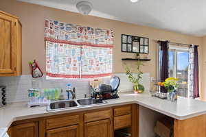 Kitchen with tasteful backsplash, sink, and kitchen peninsula