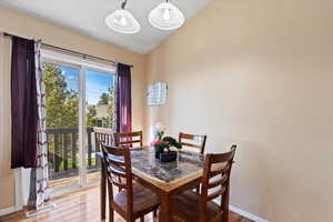 Dining area with vaulted ceiling and hardwood / wood-style floors