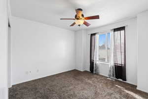 Unfurnished room with ceiling fan and carpet