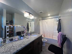 Full bathroom with toilet, hardwood / wood-style flooring, shower / bathtub combination with curtain, and vanity