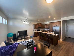 Living room featuring a textured ceiling and dark wood-type flooring