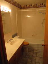 Full bathroom featuring vanity, a textured ceiling, shower / bathing tub combination, and toilet