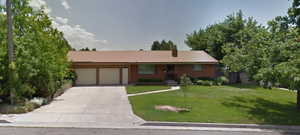 Ranch-style home featuring a front yard and a garage