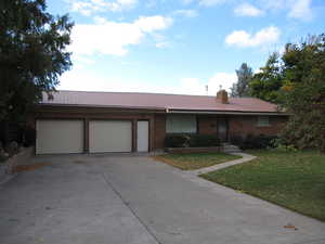 Ranch-style home with a garage and a front lawn