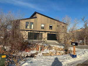 Snow covered property featuring a garage