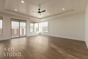 Unfurnished room with ceiling fan, dark hardwood / wood-style flooring, and a raised ceiling