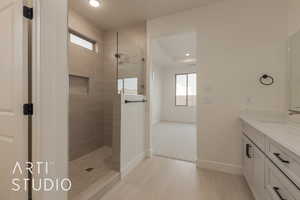 Bathroom featuring vanity, tile patterned flooring, and a tile shower