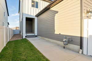 View of exterior entry featuring a yard and a patio area