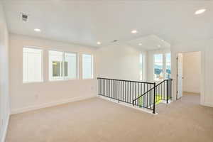 Spare room with plenty of natural light and light colored carpet