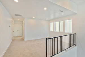 Corridor with light colored carpet