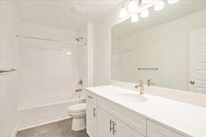 Full bathroom with toilet, bathtub / shower combination, vanity, and tile patterned floors