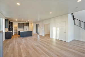 Unfurnished living room with sink and light wood-type flooring