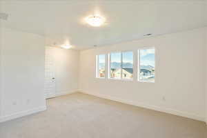 Spare room with light carpet and a textured ceiling