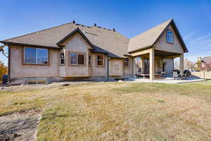 Rear view of house with cooling unit, a patio area, and a lawn