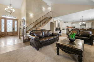 Living room featuring a notable chandelier, high vaulted ceiling, and light hardwood / wood-style flooring