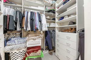 Walk in closet with light colored carpet