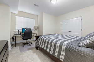 Bedroom featuring light carpet and a closet