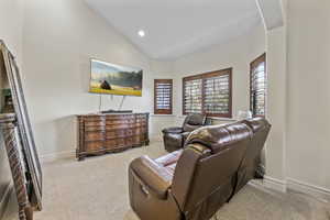 Carpeted living room featuring high vaulted ceiling