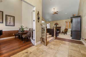 Entrance foyer featuring ceiling fan, high vaulted ceiling, and light wood-type flooring